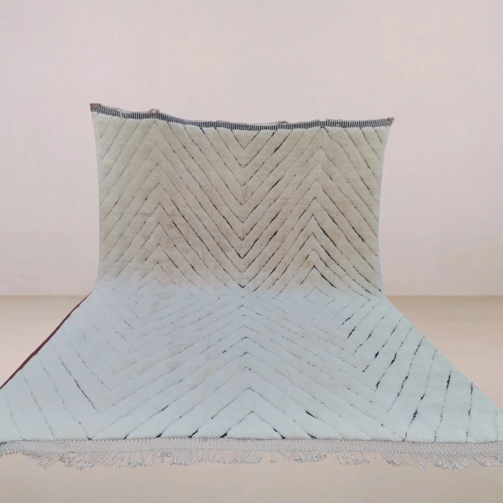 A handmade Beni Mrirt rug featuring a bold geometric pattern in ivory and black wool, crafted with traditional Moroccan weaving techniques.
