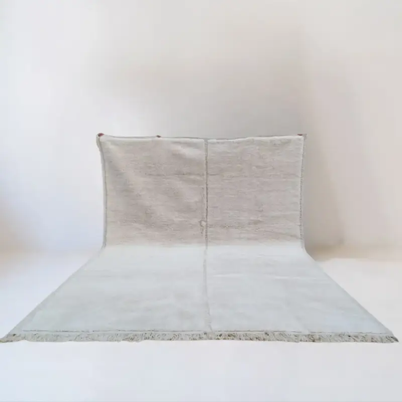 Handwoven Beni Mrirt rug featuring a minimalist solid design in soft neutral tones.