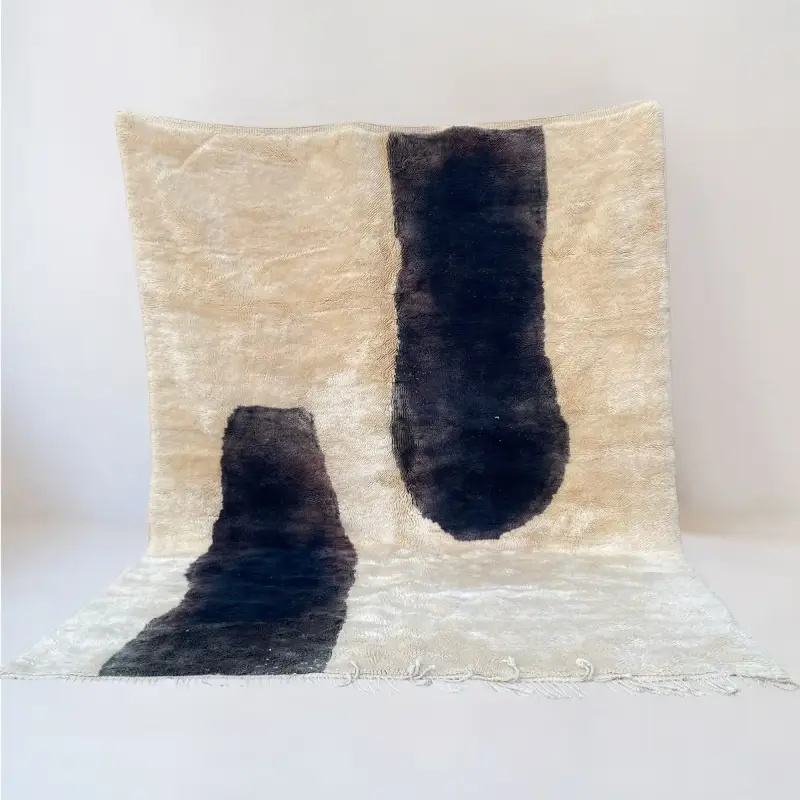A luxurious Moroccan Beni Mrirt rug featuring abstract black markings on a soft beige background, handcrafted with premium wool.