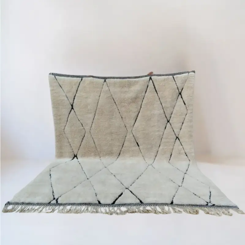 Handwoven Moroccan Beni Mrirt rug named Tazarin, featuring an elegant geometric diamond pattern in natural wool tones with black lines, crafted using traditional techniques.