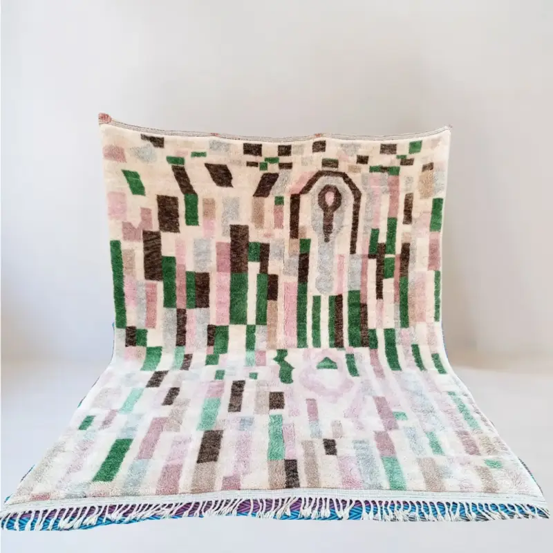 A handmade Moroccan Beni Mrirt wool rug featuring a structured and artistic design with earthy tones of green, brown, and soft pink, woven with intricate geometric elements.